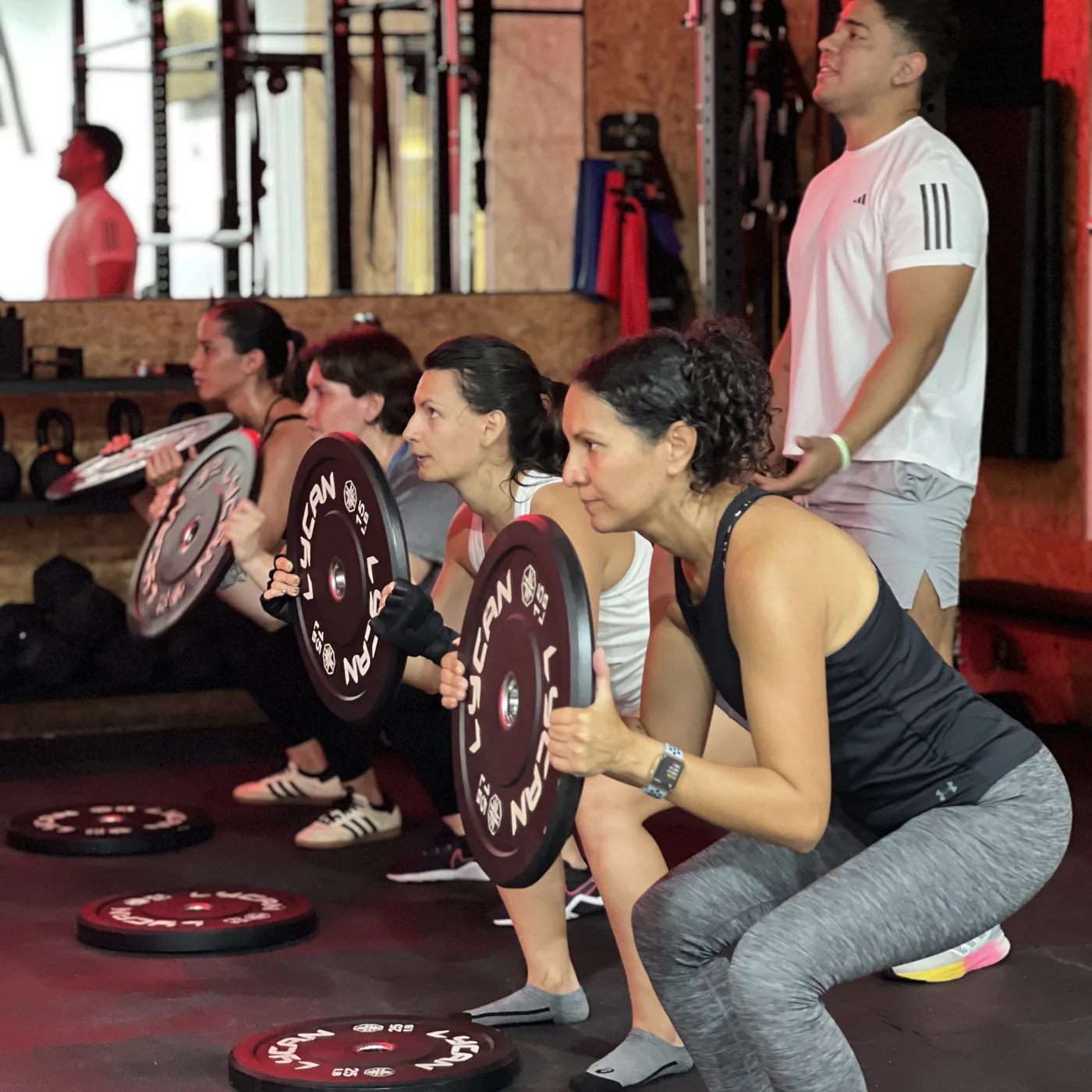 Grupo de alumnas haciendo sentadillas en KORE